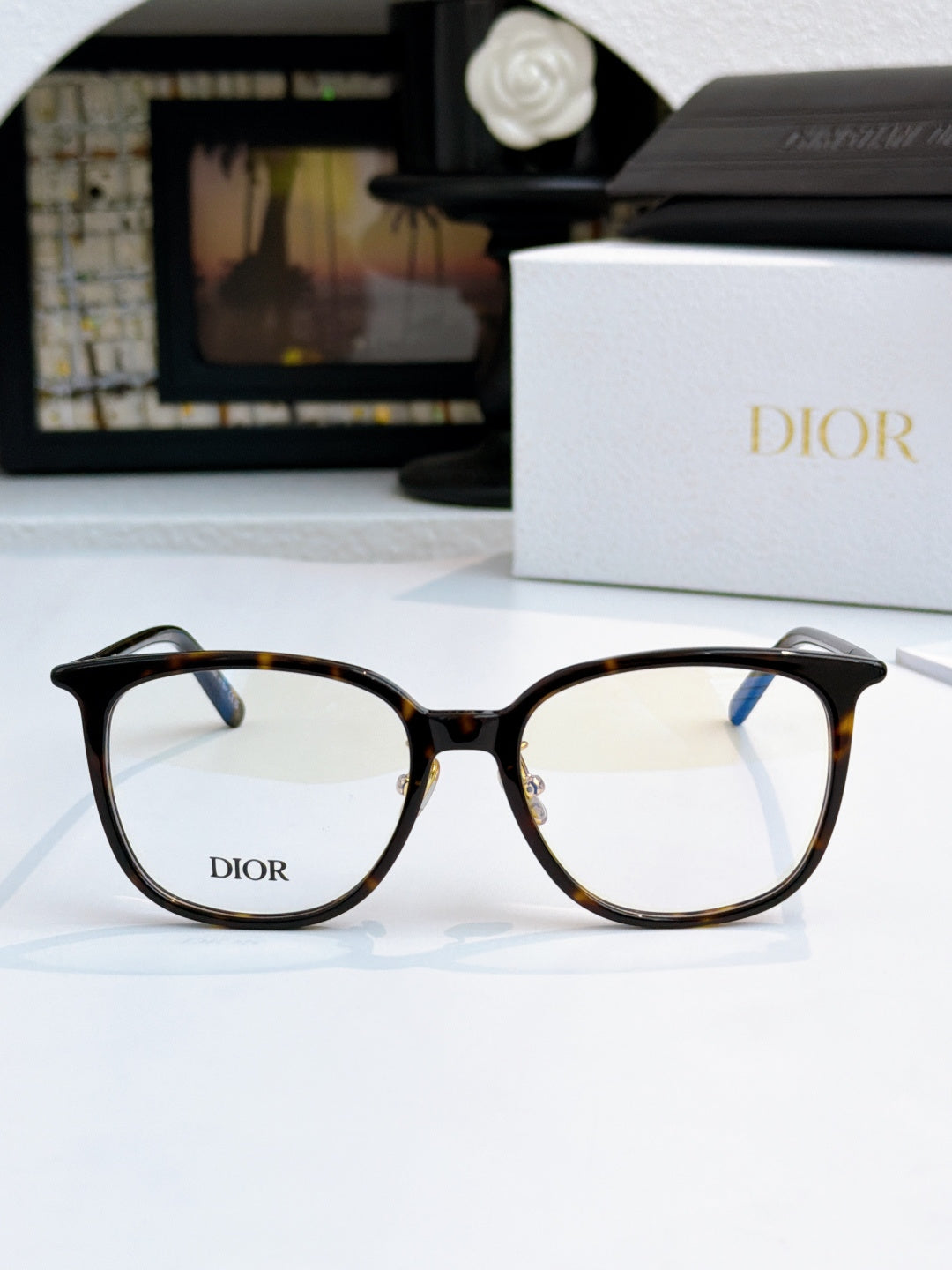 Tortoiseshell full-rim eyeglasses with Dior logo on lenses and curved temples