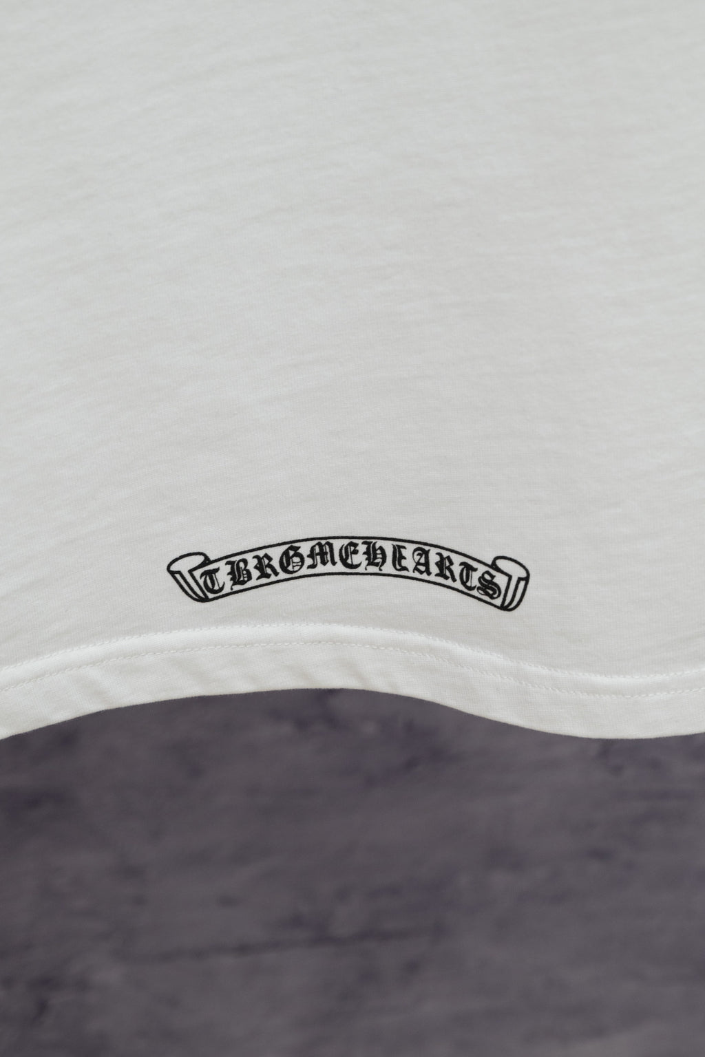 White short-sleeve T-shirt with small cursive hem logo