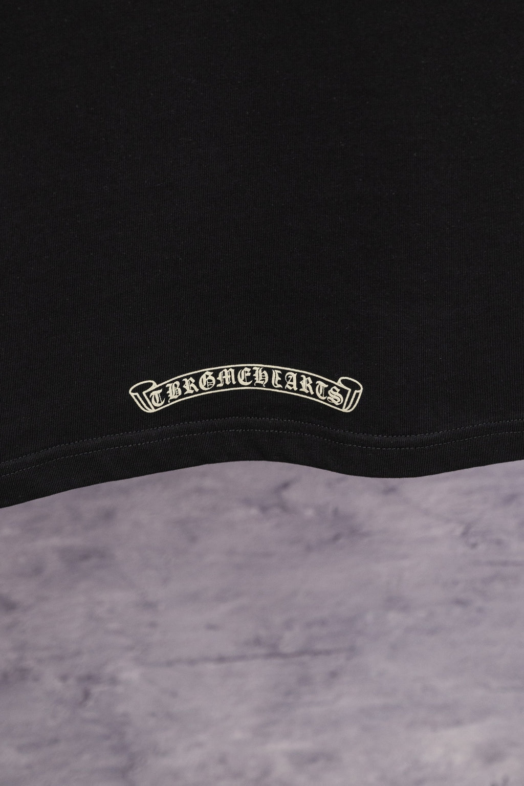 Black T-shirt with small embroidered logo at inner hem