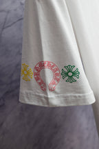 White T-shirt side hem with multicolor horseshoe-style emblem