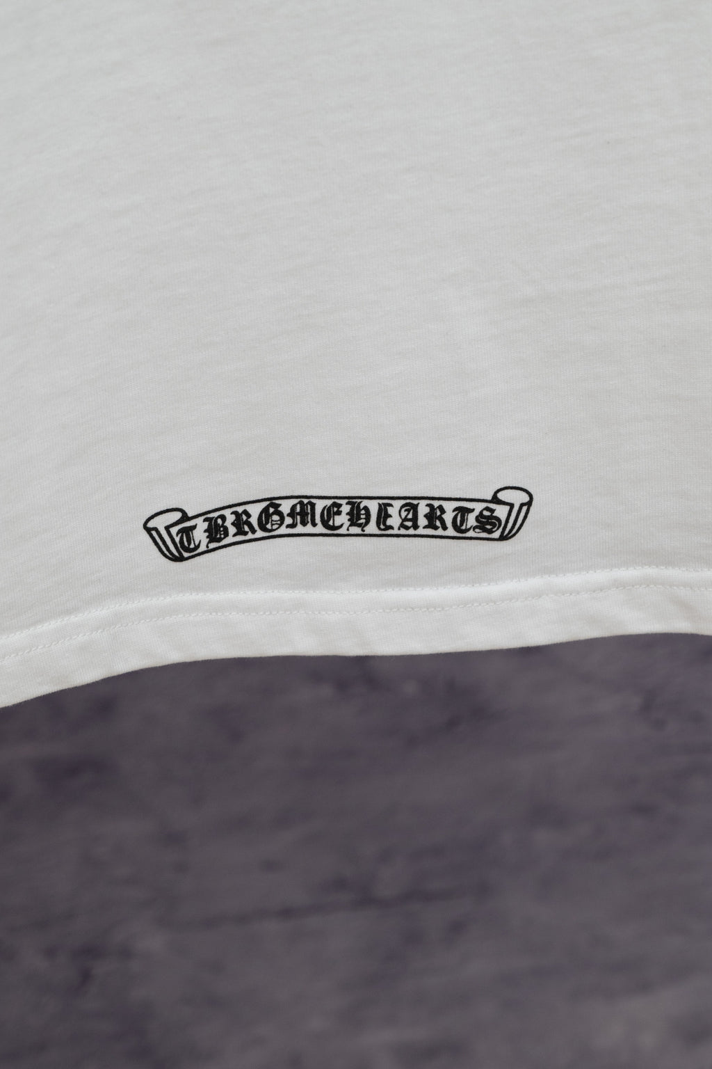 White T-shirt with small black logo text near the hem