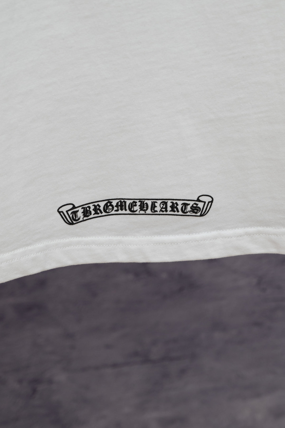 White T-shirt with small black logo text near the hem