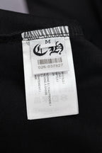 Black T-shirt size label marked M with barcode and care text