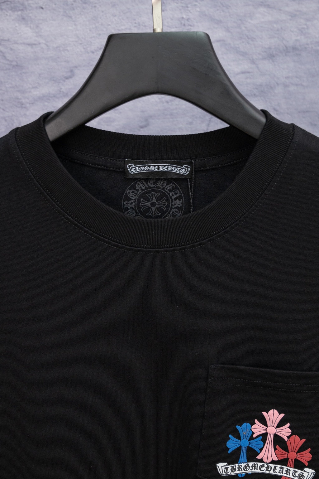 Black short-sleeve T-shirt neckline detail with chest pocket logo
