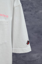 White short-sleeve T-shirt with side chest pocket and red lip patch on sleeve