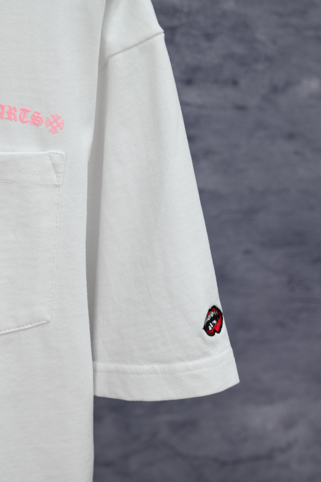 White short-sleeve T-shirt with side chest pocket and red lip patch on sleeve