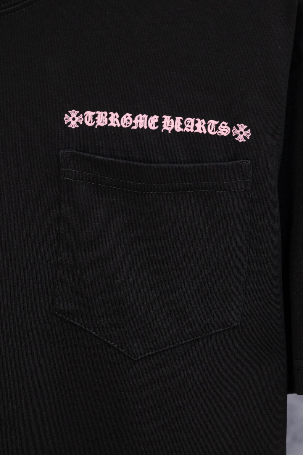Black short-sleeve T-shirt with pink Chrome Hearts logo and front chest pocket
