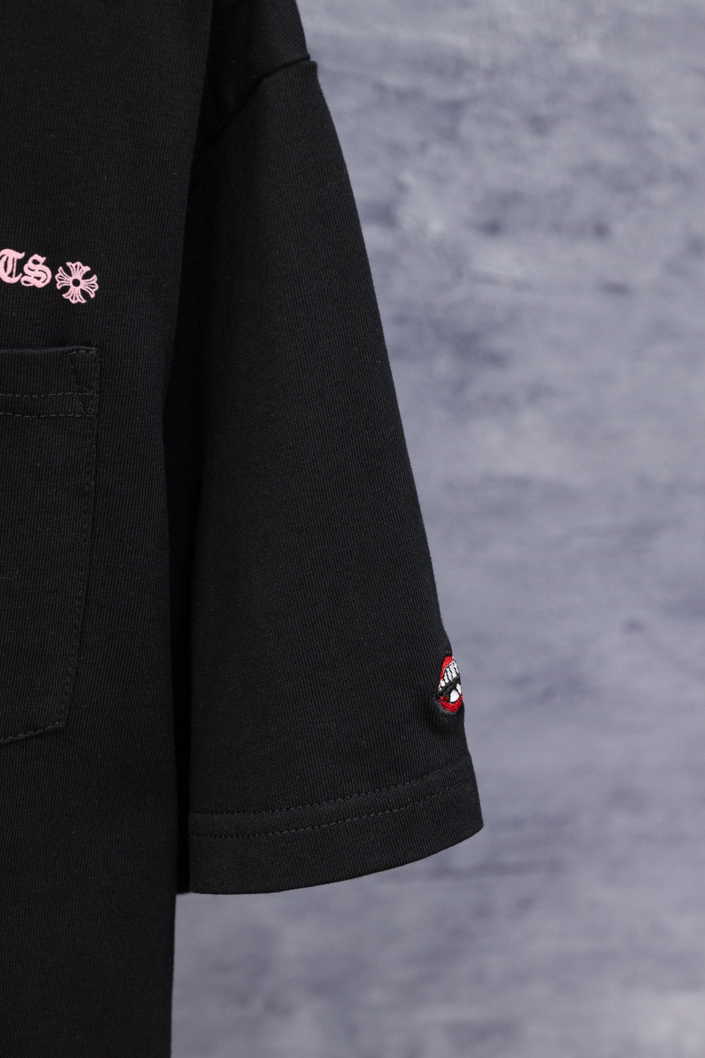 Black short-sleeve T-shirt with small Chrome Hearts logo patch on sleeve hem