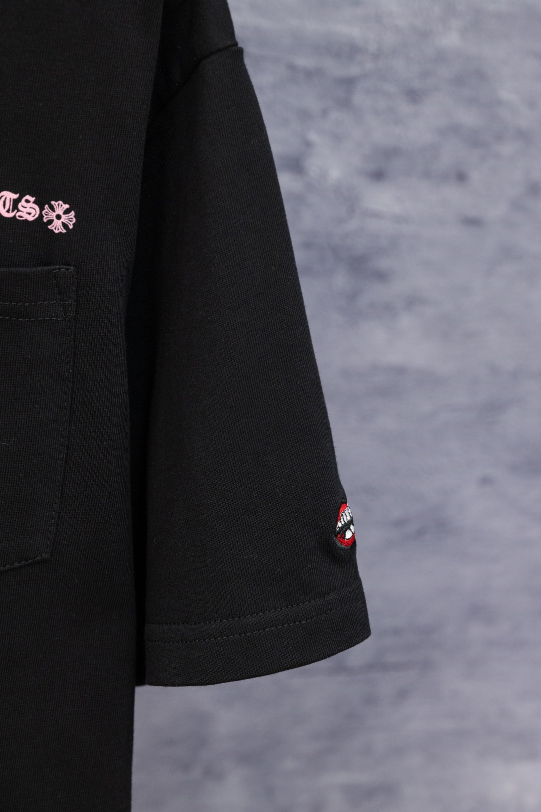 Black short-sleeve T-shirt with small Chrome Hearts logo patch on sleeve hem