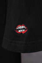 Black short-sleeve T-shirt with red and white lip embroidered patch on sleeve