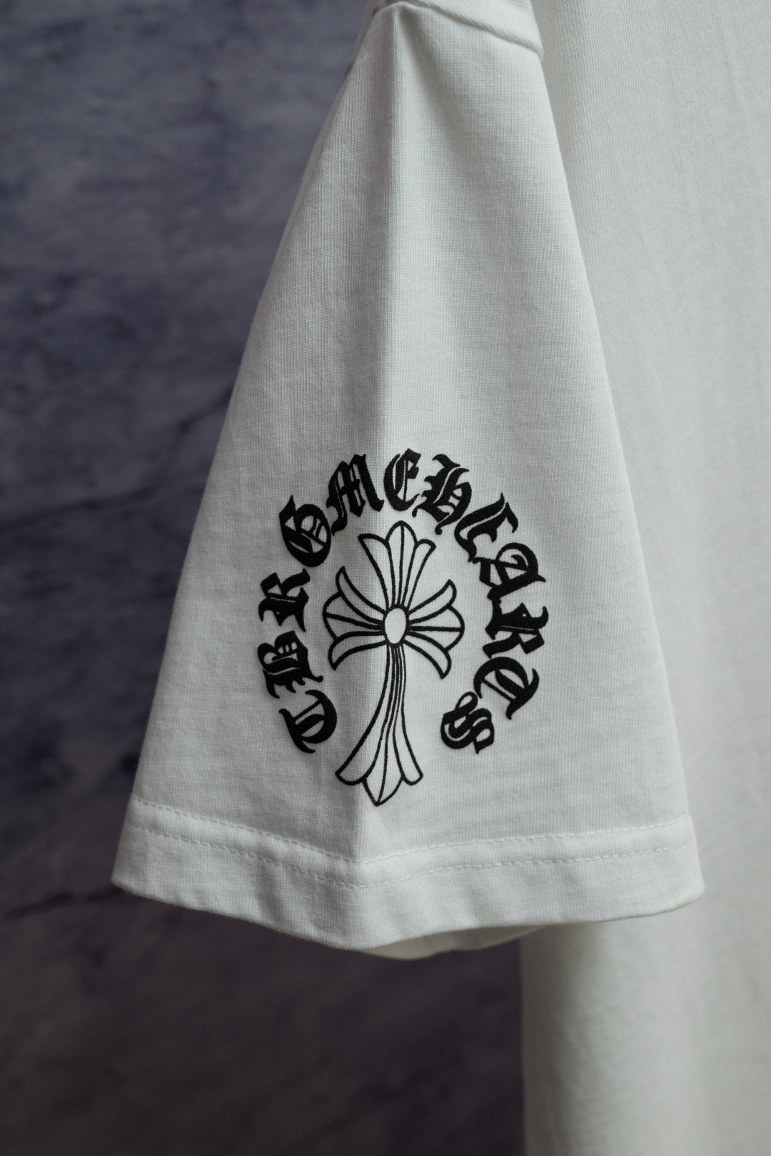 White T-shirt with black floral cross graphic on sleeve