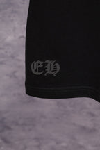 Black T-shirt lower side with small white logo near hem
