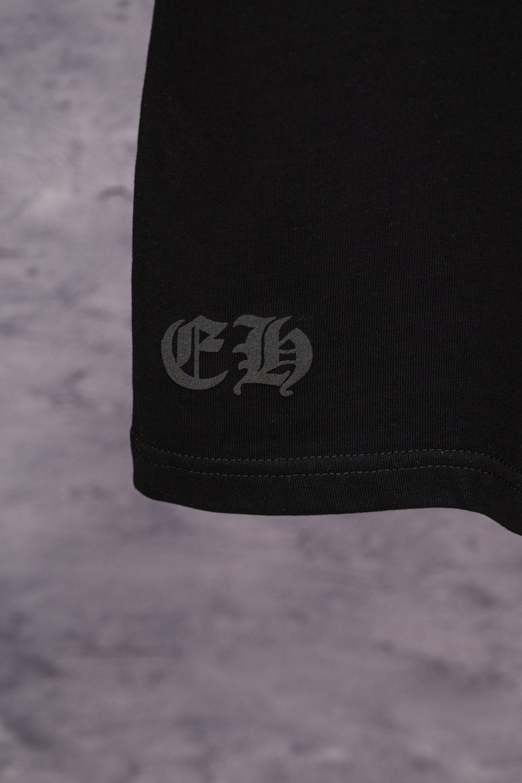Black T-shirt hem with small white side logo print