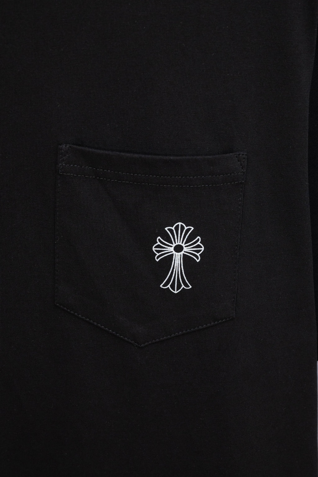 Black T-shirt chest pocket with small white cross emblem print
