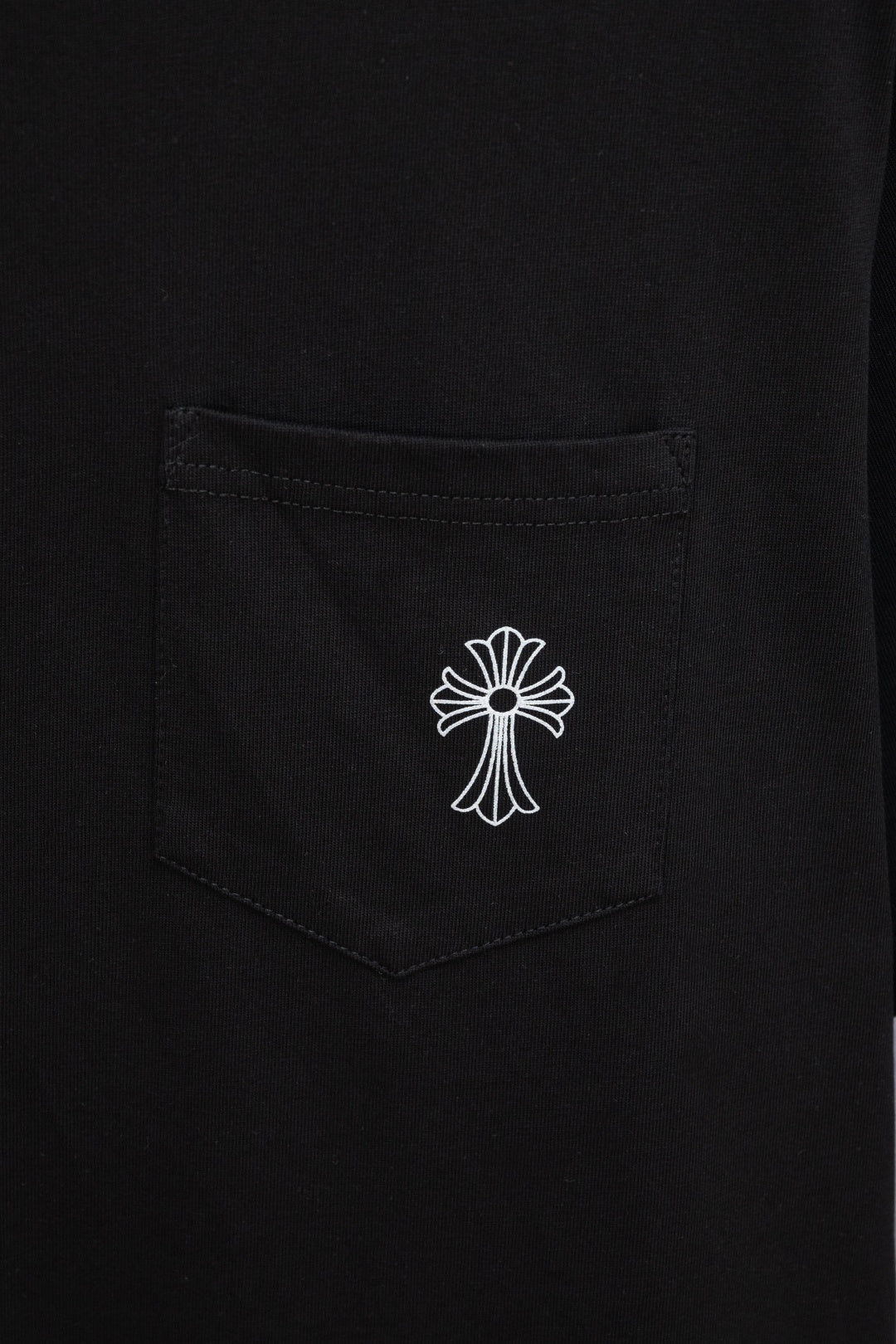 Black T-shirt chest pocket with small white cross emblem print