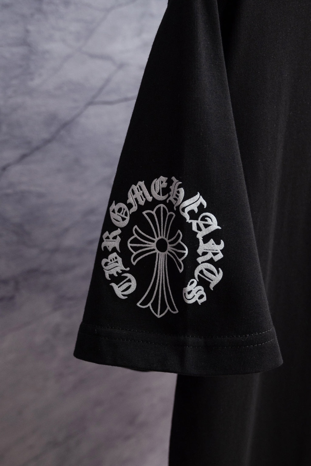 Black short-sleeve T-shirt sleeve with large white emblem graphic