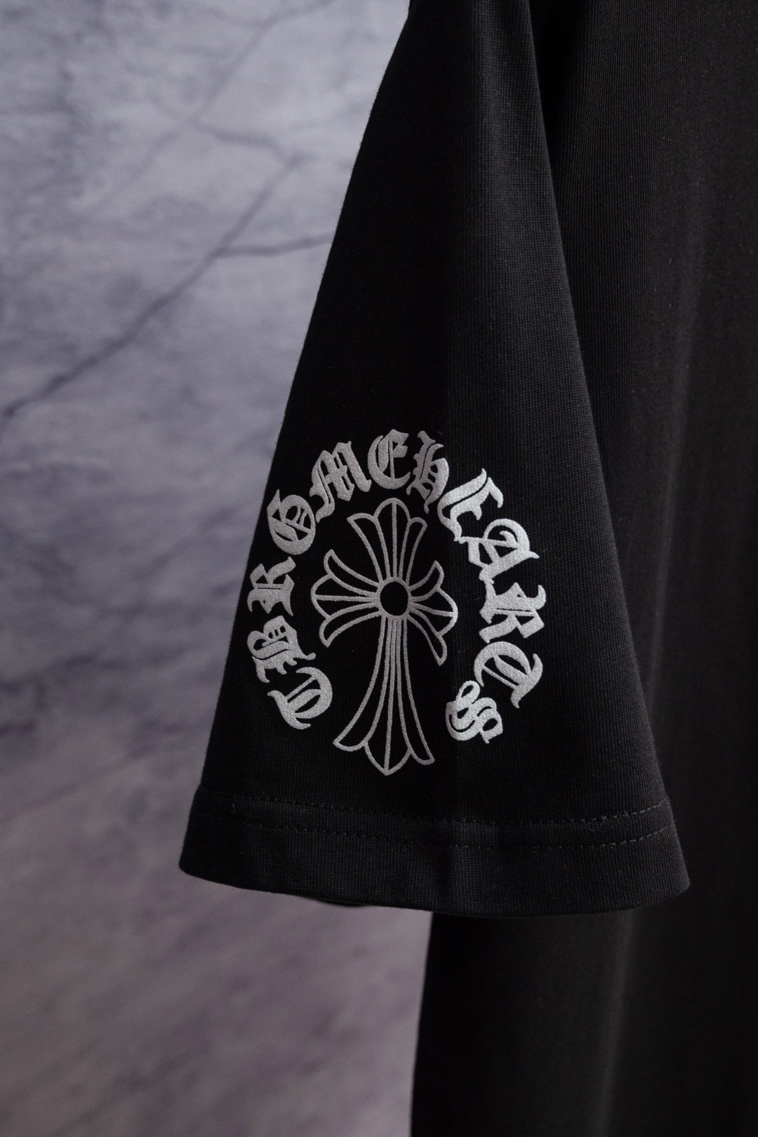 Black short-sleeve T-shirt sleeve with large white emblem graphic