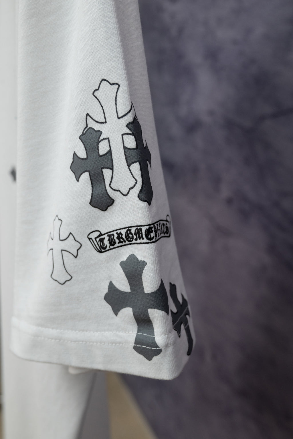 White short-sleeve T-shirt sleeve with dark cross icons and blue print