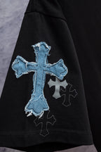 Black T-shirt sleeve detail with large blue cross embroidery