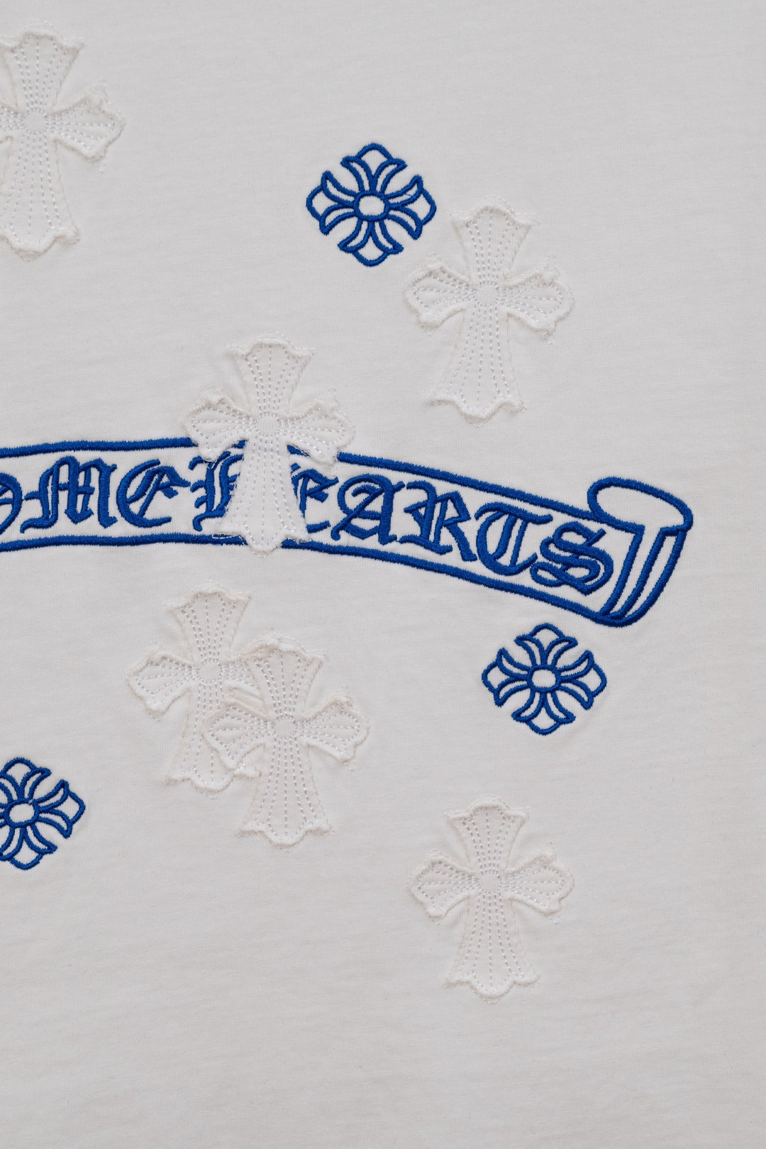 White T-shirt back detail with blue script ribbon and flower appliques