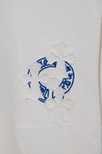 White T-shirt with blue circular embroidery and white flower appliques
