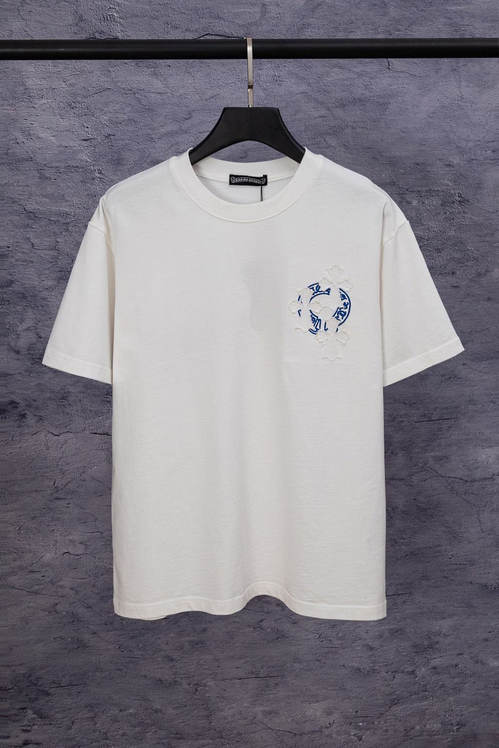 White short-sleeve T-shirt with blue chest graphic and small flower embroidery