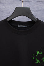 Black crewneck T-shirt with green emblem at right chest