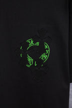 Black T-shirt with large neon-green and dark embroidered emblem