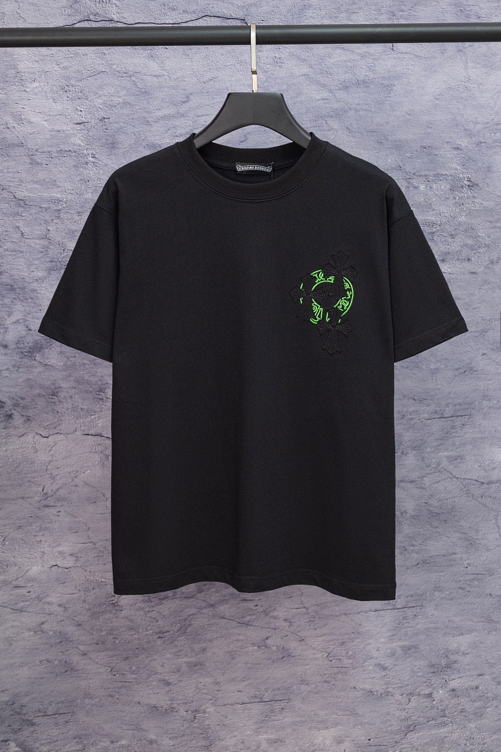 Black short-sleeve T-shirt with small neon-green emblem on chest