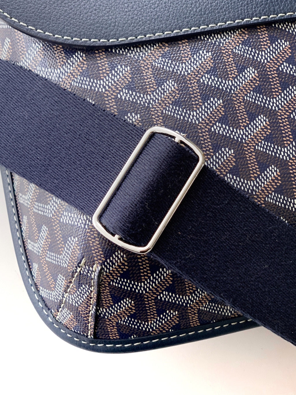 Navy strap with silver buckle on monogram shoulder bag with stitched edges