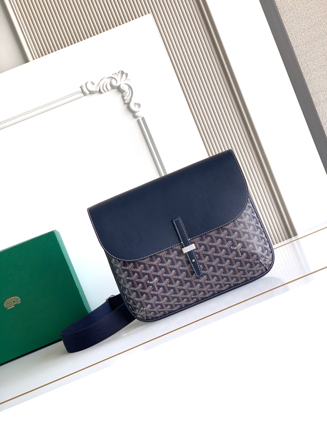 Goyard crossbody bag in navy with geometric pattern, top flap and shoulder strap.