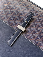 Leather tab and snap detail on navy monogram bag with stitched trim