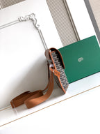 Goyard crossbody bag with open top, tan leather trim, and adjustable shoulder strap.