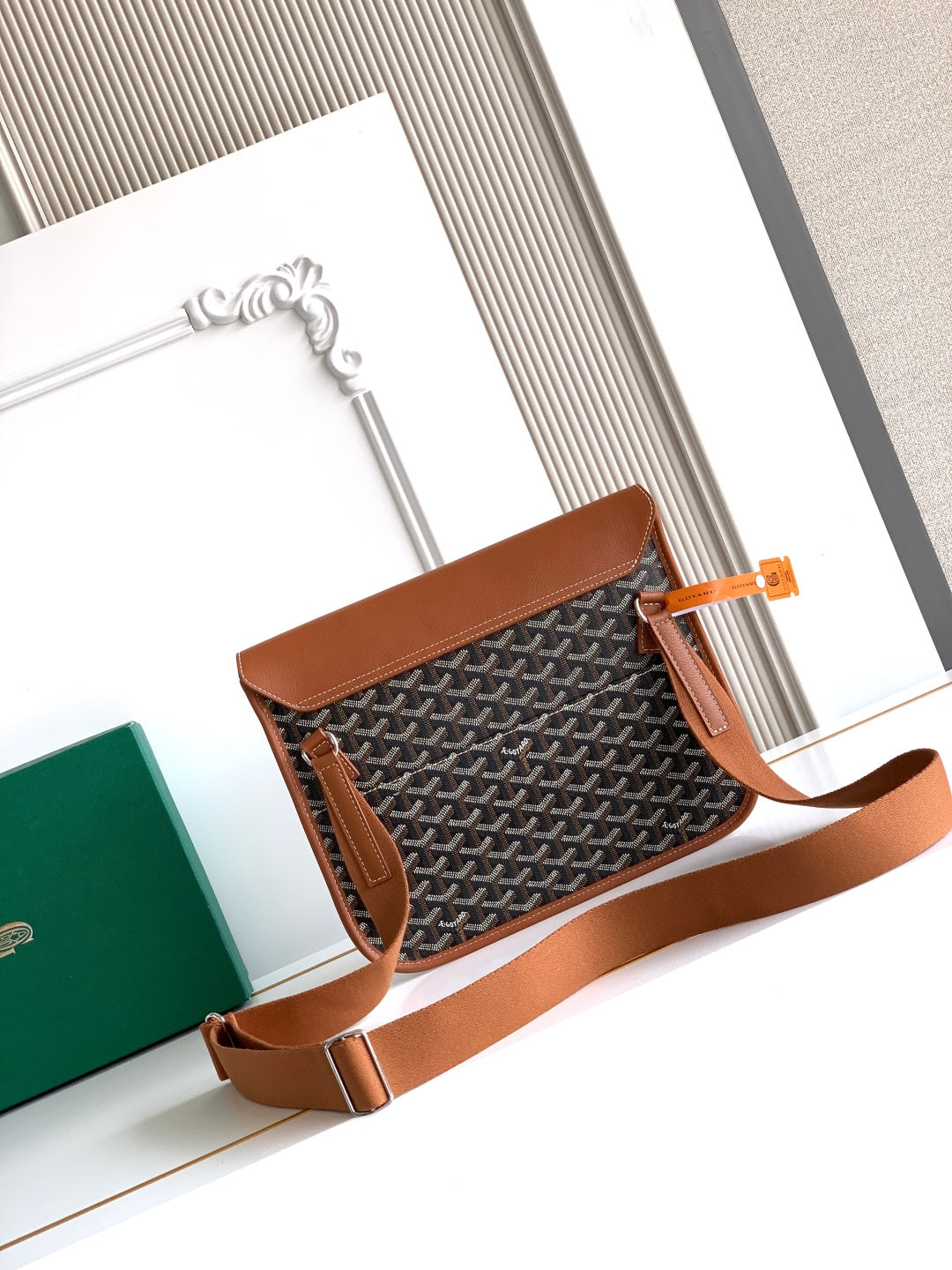 Goyard small crossbody bag with front flap and brown leather trim.