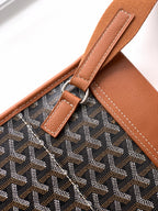 Goyard bag close-up of tan strap attachment with metal ring and stitching.