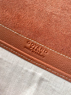 Goyard leather trim close-up with embossed logo and contrast stitching.