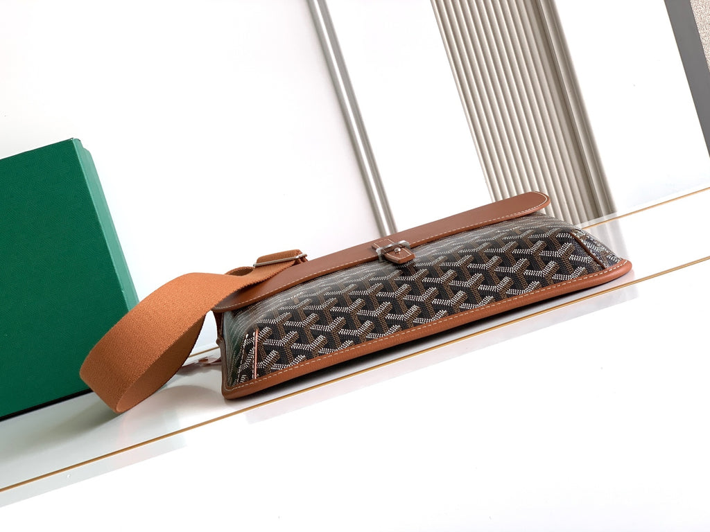 Goyard patterned bag with rectangular flap and tan leather crossbody strap.