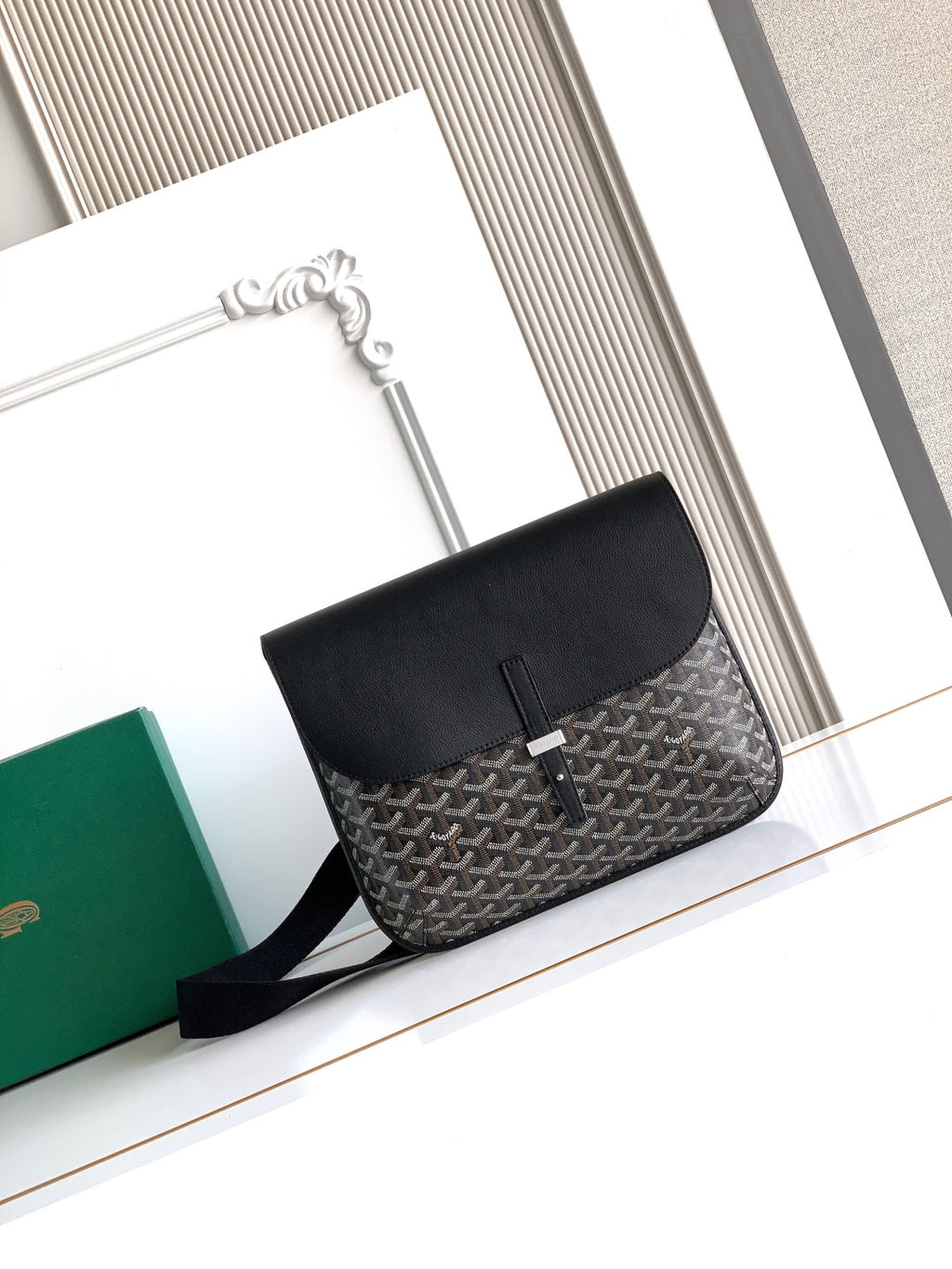 Goyard shoulder bag with black flap and gray patterned body, featuring a front strap