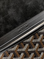 Goyard bag logo detail on black leather trim with gray patterned fabric beside it