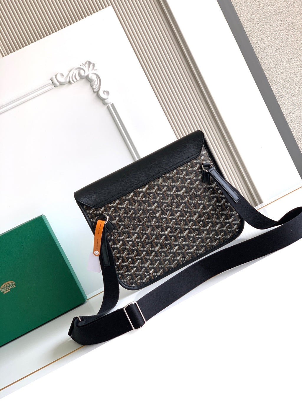 Goyard shoulder bag with black top flap, gray patterned body, and long adjustable strap
