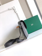 Goyard bag showing side profile with dark strap and gray patterned flap