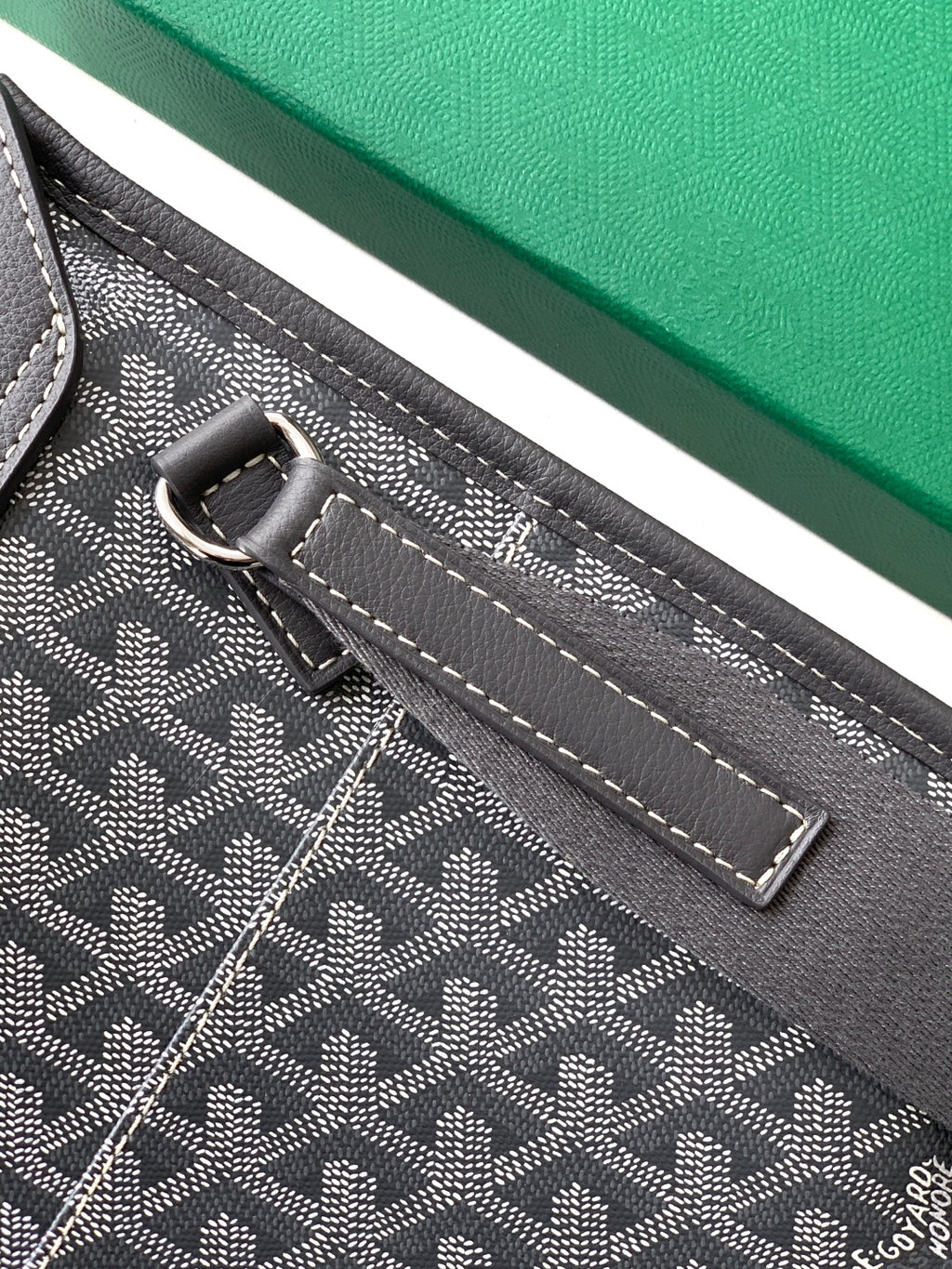 Goyard bag close-up of adjustable strap and top loop with metal hardware