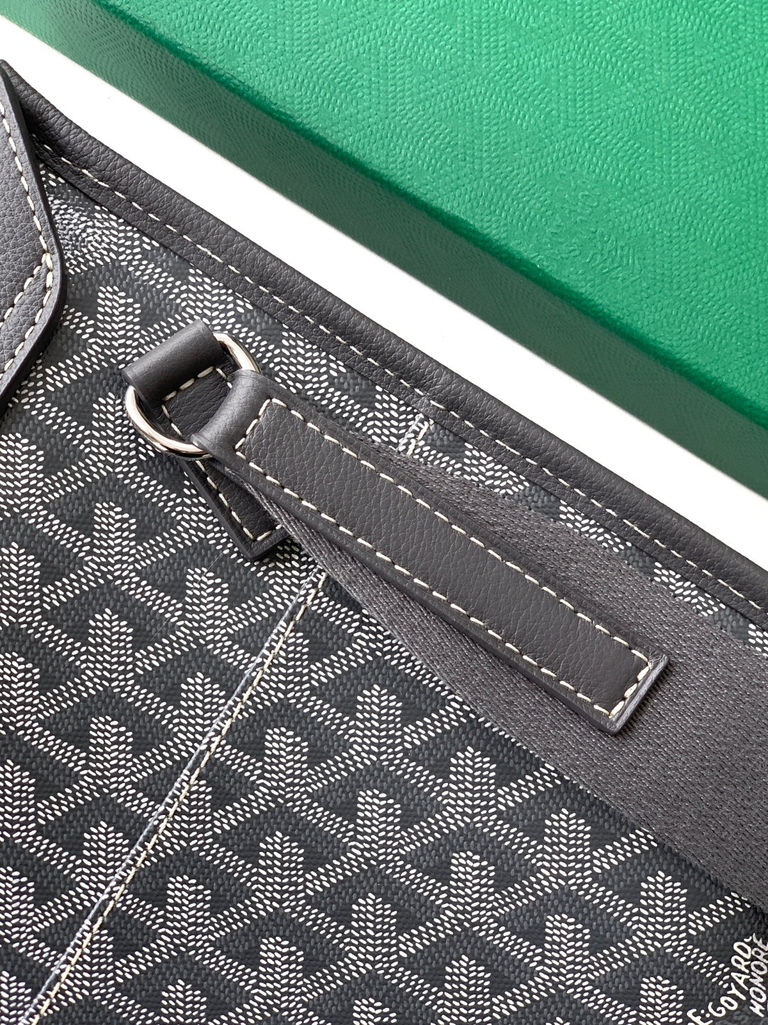 Goyard bag close-up of adjustable strap and top loop with metal hardware