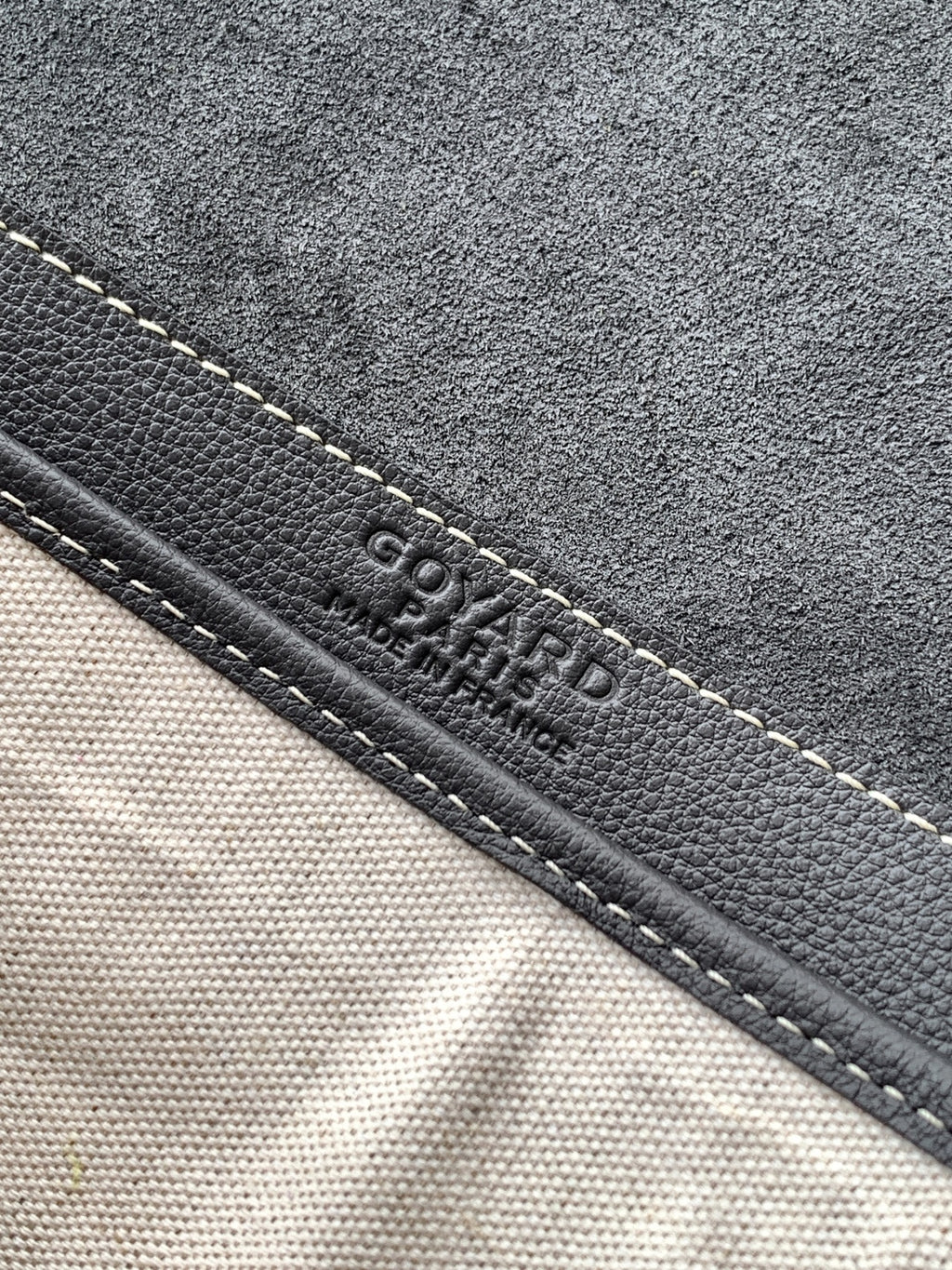 Goyard bag close-up of stitched edge with embossed Goyard text on dark trim