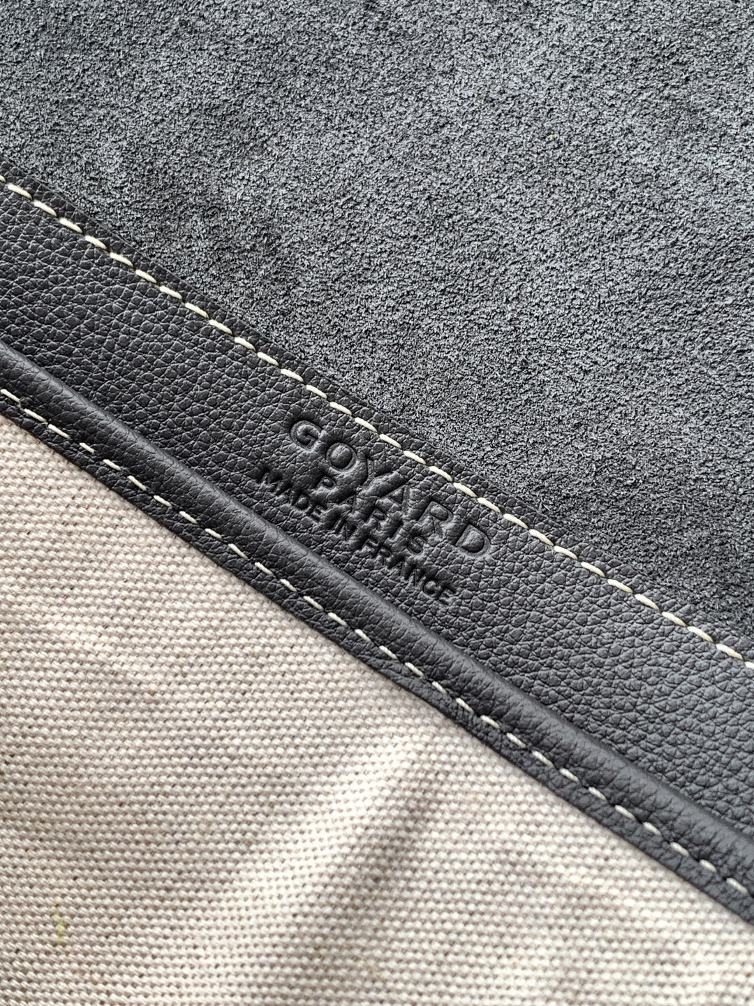 Goyard bag close-up of stitched edge with embossed Goyard text on dark trim
