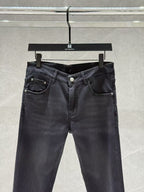 Dark denim jeans with five-pocket layout, visible belt loops, and front button closure.