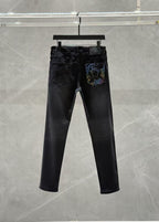 Dark denim jeans with zip fly and a colorful graphic patch on the right leg pocket.
