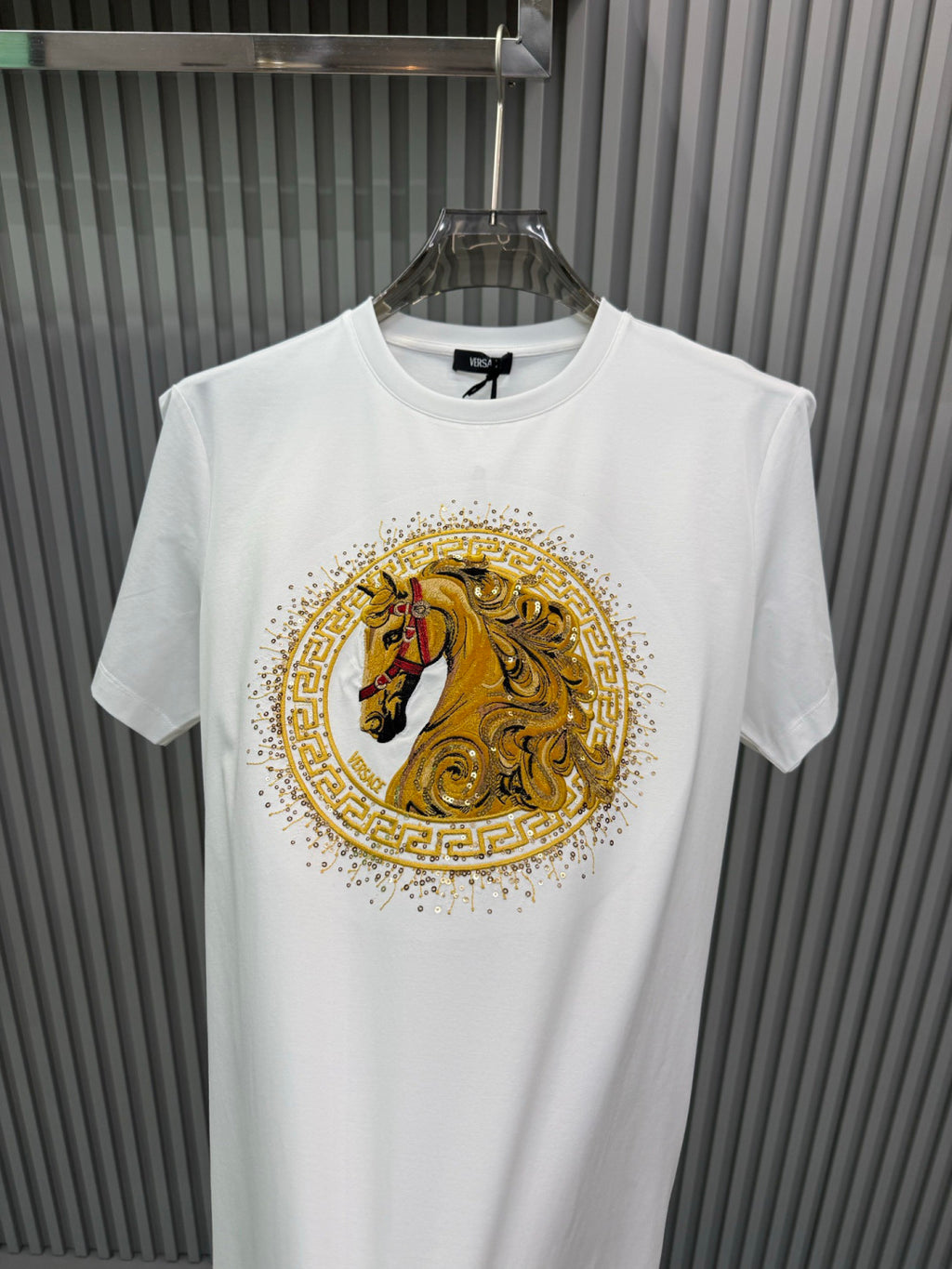 White crew-neck short-sleeve T-shirt with large gold lion medallion graphic