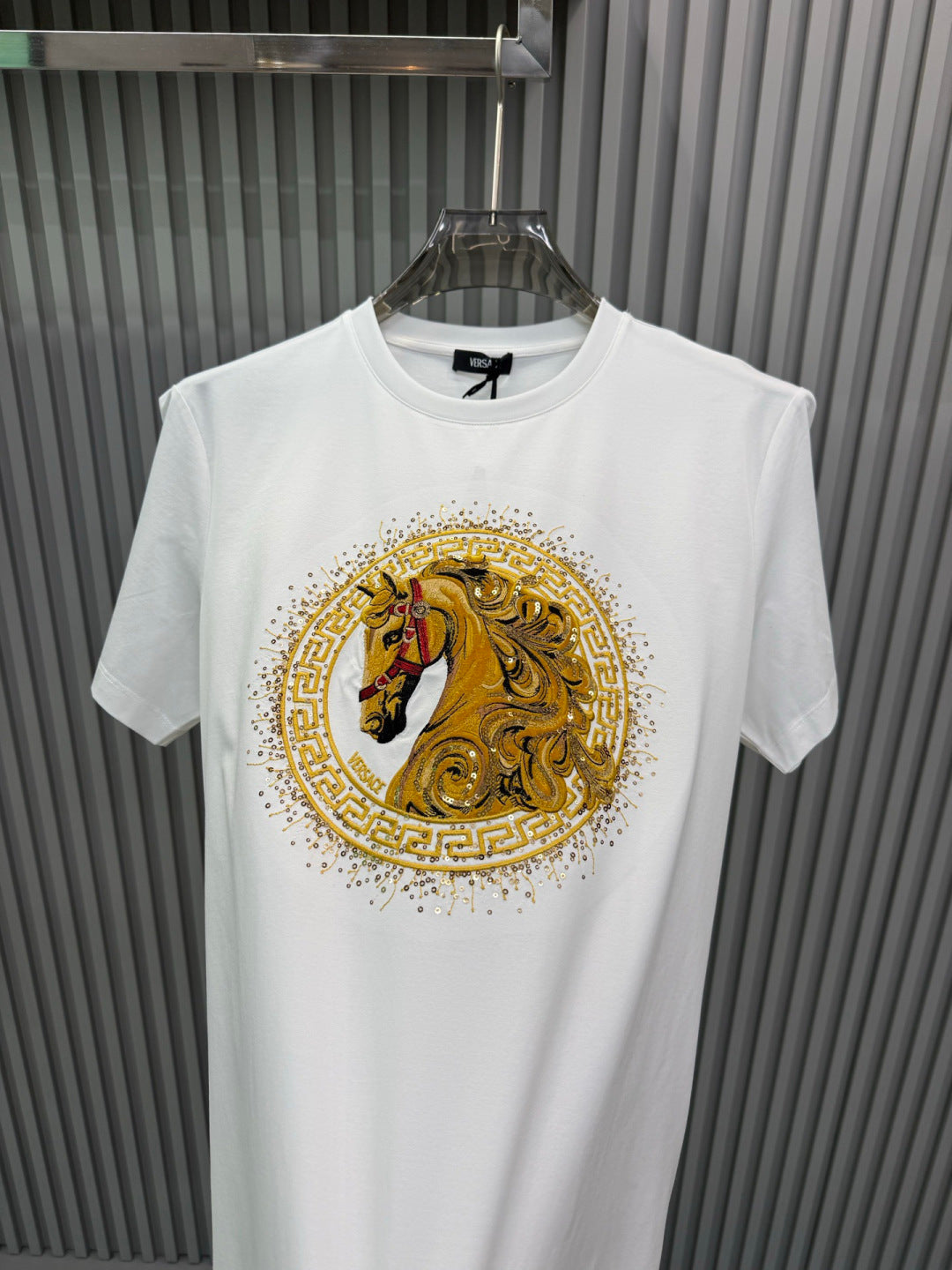 White crew-neck short-sleeve T-shirt with large gold lion medallion graphic