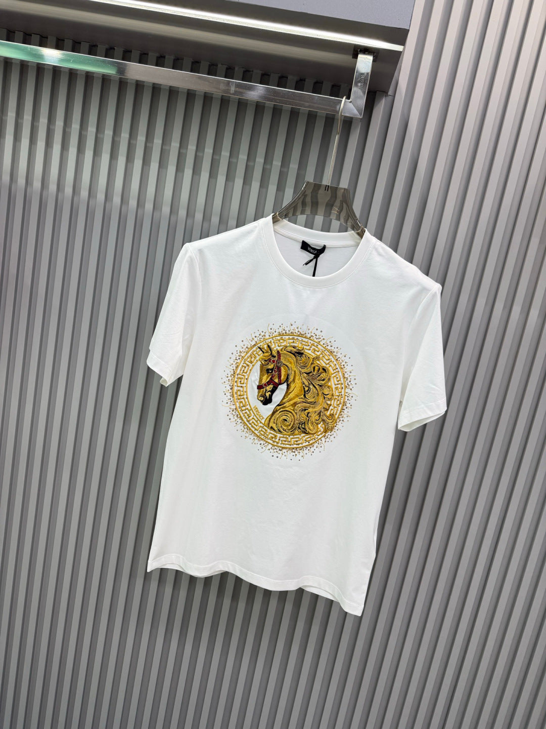 White crew-neck T-shirt with gold lion medallion print and short sleeves